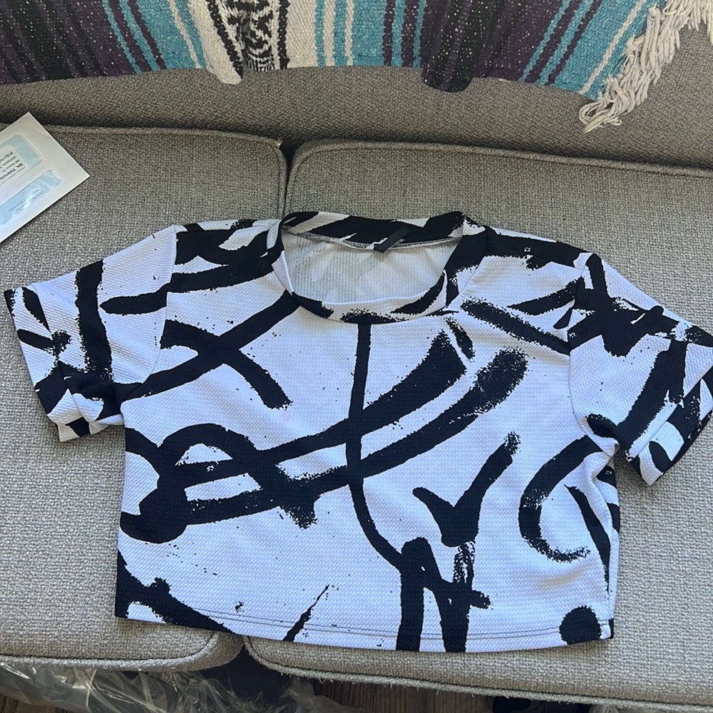 This is a black and white women’s crop top, that has cool black designs